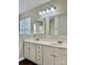 Bathroom featuring dual sink vanity with bright lighting, white cabinetry and mirrors at 12044 Brownestone View Dr, Charlotte, NC 28269