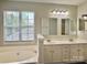 Bright bathroom showcasing a double sink vanity and relaxing tub with a large window at 12044 Brownestone View Dr, Charlotte, NC 28269
