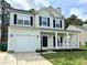 Two-story home with black shutters, front porch and an attached garage at 12044 Brownestone View Dr, Charlotte, NC 28269