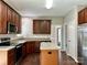 Well-lit kitchen features wood cabinets, stainless steel appliances, and an island with light countertops at 12044 Brownestone View Dr, Charlotte, NC 28269