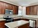 Kitchen with stainless steel appliances, wood cabinets, tile backsplash, and granite countertops at 12044 Brownestone View Dr, Charlotte, NC 28269