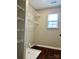 Well-lit laundry room with white wire shelving, utility sink, wood-look flooring, and window at 12044 Brownestone View Dr, Charlotte, NC 28269