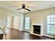 Living room featuring dark wood floors, fireplace, ceiling fan and lots of natural light at 12044 Brownestone View Dr, Charlotte, NC 28269