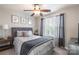 Cozy bedroom features a ceiling fan, window with curtains, and a comfortable-looking patterned bed at 1246 Rising Oak Dr, Charlotte, NC 28206