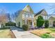 Two-story yellow home with a long driveway, lush greenery, and inviting curb appeal at 1246 Rising Oak Dr, Charlotte, NC 28206