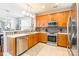 Well-lit kitchen featuring stainless steel appliances, tile backsplash, and wood cabinetry at 1246 Rising Oak Dr, Charlotte, NC 28206