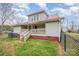 Back exterior showing covered porch with stairs, metal roof, utility connections and chain link fence at 1386 Jennings Rd, Statesville, NC 28625