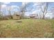 Large backyard features outbuilding and view of home with porch and metal roof at 1386 Jennings Rd, Statesville, NC 28625