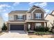 Lovely two-story home with stone accents, black garage, and professionally landscaped front yard at 15131 Oleander Dr, Charlotte, NC 28278