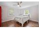 Cozy bedroom features a ceiling fan, fresh paint, wood-look flooring, and a bed with a white and blue decorative bedspread at 1755 Simplicity Rd, Concord, NC 28025