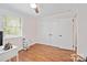 Bright bedroom with hardwood floors, closet, ceiling fan, and large window with wood blinds at 1755 Simplicity Rd, Concord, NC 28025