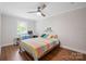 Bedroom with hardwood floors, ceiling fan, a desk, and a single bed with colorful quilt at 1755 Simplicity Rd, Concord, NC 28025