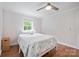 This bright bedroom features a neutral color scheme, fan, wood-look floors, and a window letting in natural light at 1755 Simplicity Rd, Concord, NC 28025