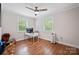 Bedroom with hardwood floors, fresh paint, two windows, a ceiling fan, and a desk area at 1755 Simplicity Rd, Concord, NC 28025
