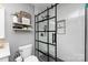 Modern bathroom featuring a sliding glass shower door, hexagon tile floor, and stylish shelving at 18861 Vineyard Point Ln, Cornelius, NC 28031
