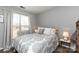 Bright bedroom features a patterned duvet cover, bedside tables and a large window at 18861 Vineyard Point Ln, Cornelius, NC 28031