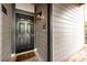 Exterior front door with welcome mat, light fixture, and light gray siding at 18861 Vineyard Point Ln, Cornelius, NC 28031