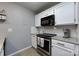 White kitchen boasts granite countertops, subway tile backsplash, and stainless steel appliances at 18861 Vineyard Point Ln, Cornelius, NC 28031