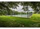Fenced tennis court surrounded by trees on a cloudy day at 18861 Vineyard Point Ln, Cornelius, NC 28031