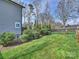 Well-maintained backyard with lush green lawn, manicured bushes, and a charming iron fence at 1905 Summey Ave, Charlotte, NC 28205