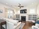 Bright living room showcasing a fireplace, built-in shelves, ceiling fan, and hardwood floors at 1905 Summey Ave, Charlotte, NC 28205
