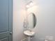 A tidy powder room features pedestal sink, an oval mirror, and a modern light fixture at 1905 Summey Ave, Charlotte, NC 28205