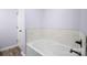 A bright bathroom features a white tub with decorative tile surround at 2021 Lennox Square Rd, Charlotte, NC 28210