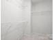 Walk-in closet featuring white wire shelving and neutral carpet at 2021 Lennox Square Rd, Charlotte, NC 28210