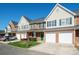 A row of brick townhomes with green shutters, garages, driveways, and green lawns at 2021 Lennox Square Rd, Charlotte, NC 28210
