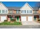 Charming brick townhouse featuring green shutters, a one car garage and a well-manicured lawn at 2021 Lennox Square Rd, Charlotte, NC 28210