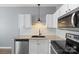 Well-lit kitchen features stainless steel appliances, white cabinets, granite countertops, and a tile backsplash at 2021 Lennox Square Rd, Charlotte, NC 28210