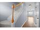 Carpeted staircase with light-colored walls, wooden handrail and landing in a well-lit home at 2021 Lennox Square Rd, Charlotte, NC 28210