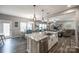 Open layout with a spacious kitchen island, stainless steel sink, and view to dining and living areas at 2076 Brightflower Ln, York, SC 29745