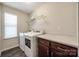 Efficient laundry room with modern washer and dryer, complemented by upper shelving and base cabinets at 2076 Brightflower Ln, York, SC 29745