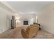Comfortable carpeted living room with a fireplace, cozy armchair, and a TV setup for relaxing evenings at 2177 Galloway Sw Ln, Concord, NC 28025