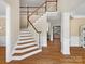 Elegant foyer showcasing a beautiful staircase, hardwood floors, and bright, neutral walls at 2907 Blackburn Dr, Waxhaw, NC 28173