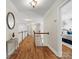 Open hallway with hardwood floors, white staircase, and neutral wall color leading to the bedrooms at 2907 Blackburn Dr, Waxhaw, NC 28173