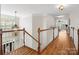 Elegant upstairs hallway with hardwood floors, white staircase, and decorative lighting at 2907 Blackburn Dr, Waxhaw, NC 28173