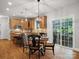 Bright kitchen with island, stainless appliances, granite counters, wooden floors, round table and view to the backyard at 2907 Blackburn Dr, Waxhaw, NC 28173