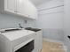 Efficient laundry room with white washer and dryer, storage shelves, and overhead cabinets at 2907 Blackburn Dr, Waxhaw, NC 28173
