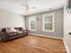 Spacious living room with hardwood floors, plentiful light, and a comfortable brown leather sofa at 2907 Blackburn Dr, Waxhaw, NC 28173