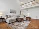 Spacious living room with a sectional sofa, leather ottoman, and high ceilings leading to a second-floor balcony at 2907 Blackburn Dr, Waxhaw, NC 28173