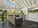 Relaxing covered porch featuring comfortable seating, an outdoor television, and a view of the backyard at 2907 Blackburn Dr, Waxhaw, NC 28173