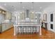 Bright kitchen features a large marble island with seating, stainless steel appliances, and hardwood floors at 3013 Arsdale Rd, Waxhaw, NC 28173