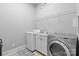 Functional laundry room with washer, dryer, countertop space, and storage shelves at 3013 Arsdale Rd, Waxhaw, NC 28173
