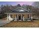 Charming home showcasing its inviting front porch, updated landscaping, and well-manicured lawn at 407 S Spargo St, Dallas, NC 28034
