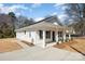 Side angle showing modern new home with ample drive, trimmed front yard, and spacious front porch at 407 S Spargo St, Dallas, NC 28034