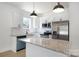 Modern kitchen featuring stainless steel appliances, granite countertops, and white subway tile backsplash at 407 S Spargo St, Dallas, NC 28034