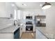 Bright kitchen with stainless steel appliances, granite counters, white subway tile backsplash, and island seating at 407 S Spargo St, Dallas, NC 28034