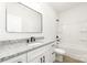 Clean bathroom with a gray and white vanity, dark fixtures, and shower-tub combo with white surround at 409 S Spargo St, Dallas, NC 28034
